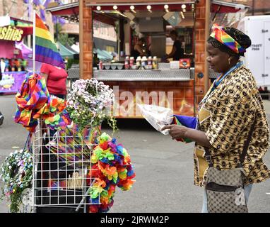 Manchester, Regno Unito. 26th agosto, 2022. Un venditore di strada vende arcobaleno paraphernalia. LGBTQ+ Pride, Manchester, Regno Unito, inizia e continua durante il fine settimana delle festività dal 26th al 29th agosto nel villaggio gay di Manchester. Gli organizzatori dicono: 'Manchester Pride è una delle principali associazioni di beneficenza del Regno Unito LGBTQ+. La nostra visione è un mondo in cui le persone LGBTQ+ sono libere di vivere e amare senza pregiudizi. Facciamo parte di un movimento Pride globale che celebra l'uguaglianza LGBTQ+ e la sfida della discriminazione." Credit: Terry Waller/Alamy Live News Foto Stock