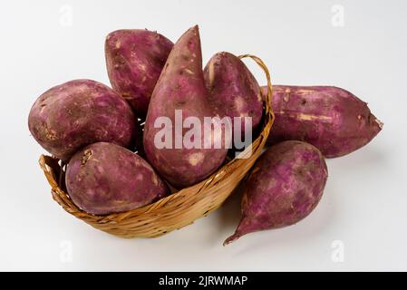 Patate dolci in un cestino isolato su fondo bianco. Foto Stock