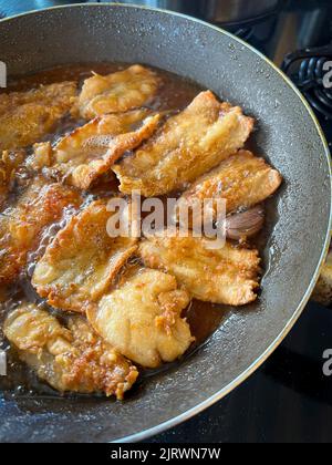 Il pesce viene fritto in una padella con olio. Cibo fritto. Foto Stock