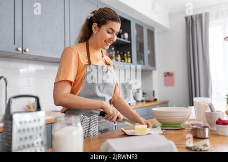 donna che cucinano il cibo e che cuoce in cucina a casa Foto Stock