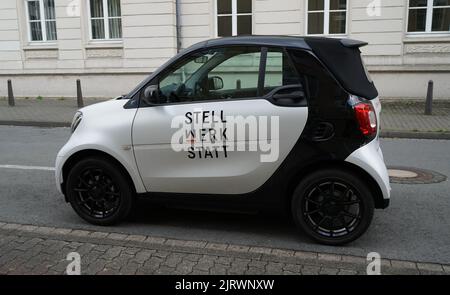 Detmold, NRW, Germania - Agosto 20 2022 Un'auto elettrica carina in bianco e nero con un nome di azienda su di esso. Smart EQ ForTwo Electric Drive Foto Stock