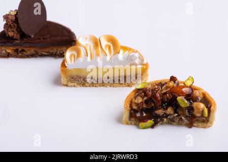 Tre pezzi di torte tagliate a metà isolate su fondo bianco Foto Stock