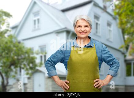 ritratto di donna anziana sorridente in grembiule da giardino Foto Stock