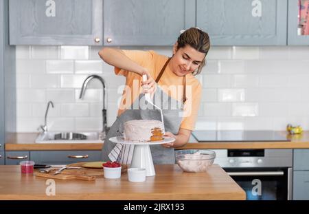 donna che cucinano il cibo e che cuoce in cucina a casa Foto Stock