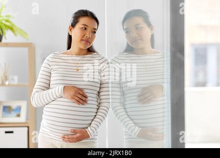 donna asiatica incinta a casa Foto Stock