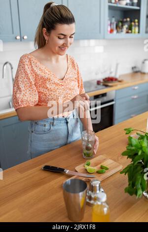 donna che fa cocktail bevande in cucina a casa Foto Stock