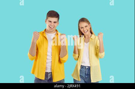 Giovane uomo e donna caucasica che si rallegra di un evento o di un successo che fa un gesto vincente Foto Stock