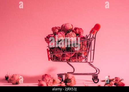 concettuale fiore shopping carrello sfondo rosso Foto Stock