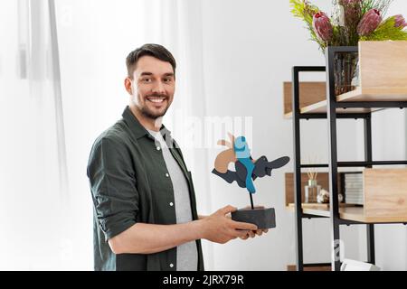 uomo che decora casa con l'arte in cornice Foto Stock