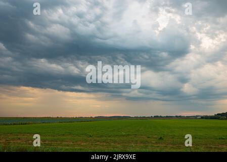 Nuvole di tempesta drammatiche sulle praterie all'alba Foto Stock