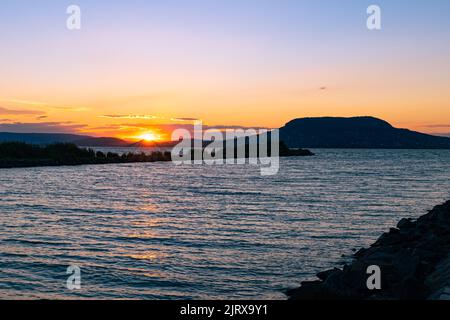 Il sole tramonta sulle colline vulcaniche sulla riva nord-occidentale del lago Balaton, Ungheria Foto Stock