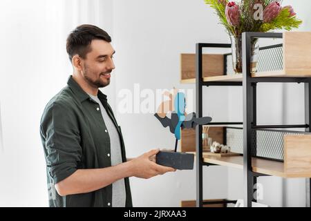 uomo che decora casa con l'arte in cornice Foto Stock