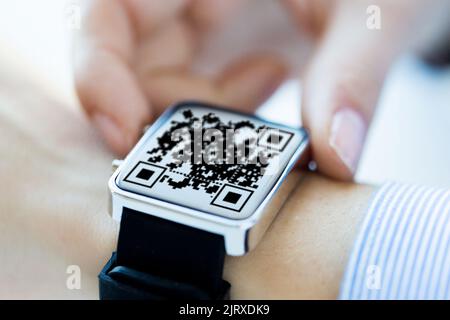 mani da donna con codice qr sull'orologio intelligente Foto Stock