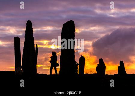 Orkney, Regno Unito. 26th ago, 2022. I visitatori possono ammirare il tramonto al Ring of Brodgar, Orkney. Le massicce pietre di 5.000 anni fanno parte del cuore delle Orcadi Neolitiche, patrimonio mondiale dell'umanità. Credit: Peter Lopeman/Alamy Live News Foto Stock