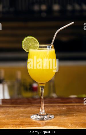 Succo d'arancia servito in un bicchiere e decorato con una fetta di limone in un ristorante. Atmosfera estiva Foto Stock