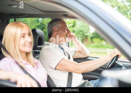 Coppia anziana felice che va in viaggio in macchina Foto Stock