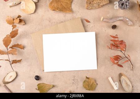 Autunno carta bianca mockup con busta per il giorno del ringraziamento su sfondo beige naturale. Preparazione delle vacanze e layout creativo. Scherzoso ringraziamento Foto Stock