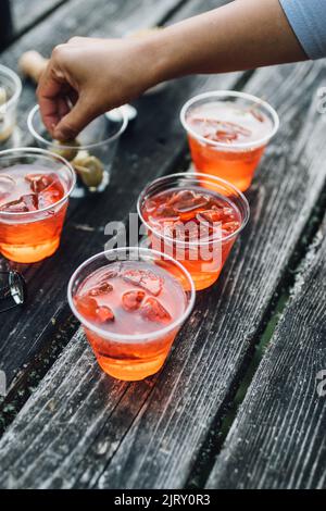 Preparare aperol spritz cocktail all'aperto sul tavolo da picnic Foto Stock