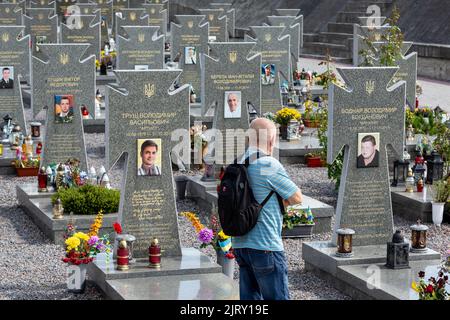 Lviv, Ucraina. 26th ago, 2022. Un uomo visita una tomba di un soldato caduto, ucciso dai separatisti russi durante la guerra tra il 2014 e il 2022 al cimitero di Lychakiv, mentre l'invasione russa supera i 6 mesi. La città di Lviv ha selezionato una fessura separata di terra al cimitero per i soldati caduti nella lotta con la Russia, i militari sono ampiamente considerati come eroi nazionali. Credit: ZUMA Press, Inc./Alamy Live News Foto Stock