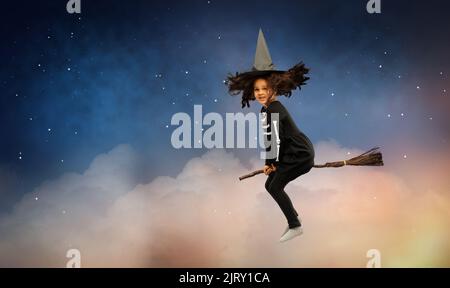 ragazza in cappello di strega nero con scopa a halloween Foto Stock