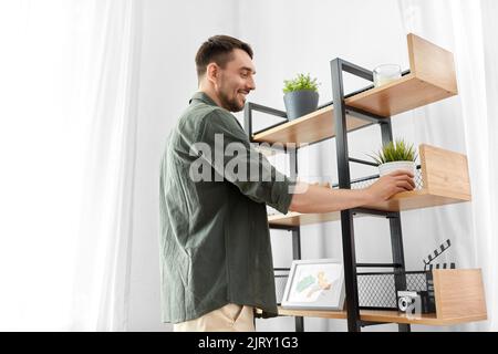 l'uomo che decora la casa con e che dispone la mensola Foto Stock