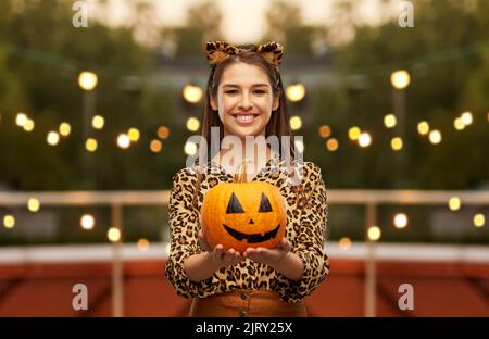 donna in costume di halloween di leopardo con zucca Foto Stock