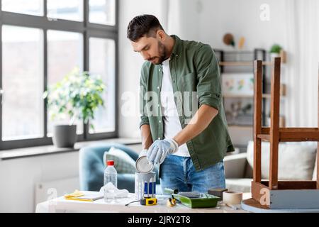 uomo apertura lattino con colore grigio a casa Foto Stock