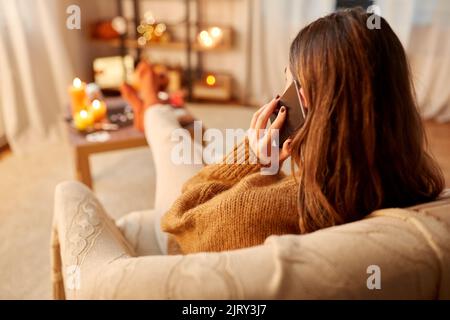 donna che chiama su smartphone a casa su halloween Foto Stock