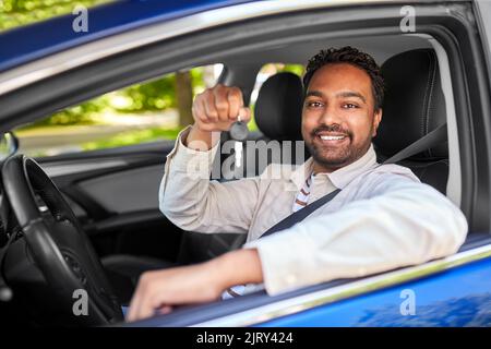 uomo o autista indiano sorridente che mostra la chiave dell'auto Foto Stock