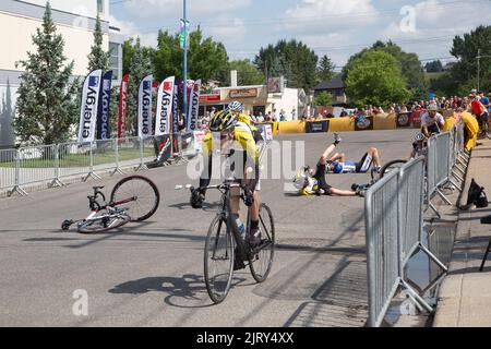 Due gare di bicicletta sdraiati in strada dopo essere cadenti a 'crash corner' sul Tour de Bowness criterium, una gara di ciclismo su strada urbana a Calgary, Canada Foto Stock