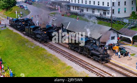 Cass, West Virginia, 18 giugno 2022 - Vista aerea di cinque motori a vapore Shay, riscaldamento per una parata di vapore con tutti e cinque i motori in un giorno estivo soleggiato Foto Stock