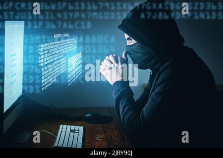 Non sai mai chi ti guarda online. Un giovane hacker che usa un computer a tarda notte. Foto Stock