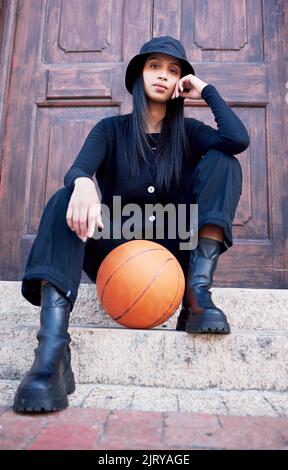 Basket, moda e model influenzer di una donna che si posa a passi in una città urbana con stile alla moda. Ritratto femminile di tendenza, elegante e. Foto Stock