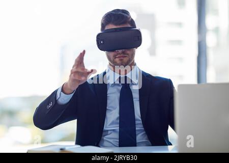 Riunione nello spazio virtuale. Un uomo d'affari che indossa un visore VR mentre lavora in ufficio. Foto Stock