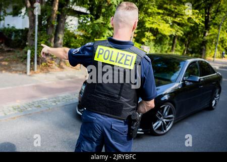 Berlino, Germania. 24th ago, 2022. Un ispettore senior della polizia di Berlino ferma un'auto durante un controllo del traffico effettuato dalla polizia di Berlino su Fulhamer Allee, nel quartiere Neukölln di Berlino, vicino a una scuola. (A dpa: 'I trasgressori di traffico portano gli stati e i comuni più entrate') Credit: Christoph Soeder/dpa/Alamy Live News Foto Stock