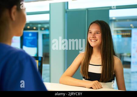 Appena schioccando dentro per il mio controllo annuale. Immagine retroveruta di un infermiere che saluta un giovane paziente in clinica. Foto Stock