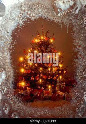 Candele brucianti nell'albero di Natale con le candele ed i regali, Bescherung, Weihnachtszeit, Avvento, molle, Albero di Natale con regali di fronte Foto Stock