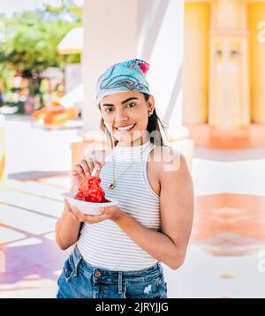 Ritratto di ragazza sorridente che tiene il ghiaccio rasato in strada. Giovane donna che tiene una tazza di ghiaccio rasato sulla strada. Concetto di una ragazza con un Nicaragua Foto Stock