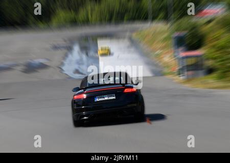 Foto dinamica con effetto zoom dell'auto sportiva Audi TT inizia a mantenere il controllo durante il corso slalom durante l'addestramento alla sicurezza di guida, FSZ II sicurezza di guida Foto Stock