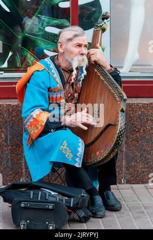 Un Kobzar che canta al suo proprio accompagnamento su uno strumento bandura in via Khreshchatyk a Kiev, Ucraina. Un Kobzar è un rione ucraino itinerante. Foto Stock
