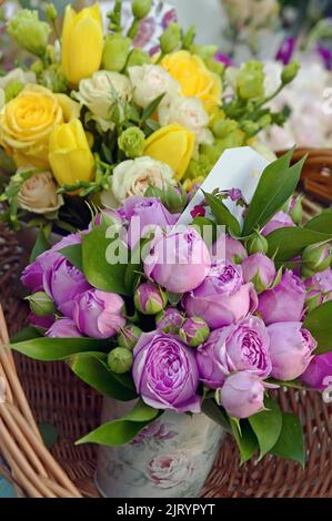 Bouquet di rose gialle e rosa in cesto di paglia Foto Stock