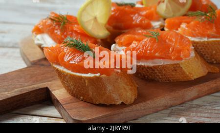 Panini aperti con filetto di trota, pane di grano con burro ed erbe aromatiche Foto Stock