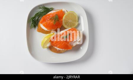 Panini aperti con filetto di trota, pane di grano con burro ed erbe aromatiche Foto Stock