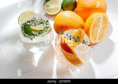 Cocktail forti con seltzer con lime e cocktail duri con seltzer bevanda alcolica con tonico e arancione su sfondo chiaro. Vista dall'alto Foto Stock
