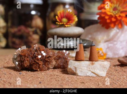 Cristallo di aragonite con coni di incenso sulla sabbia rossa australiana Foto Stock