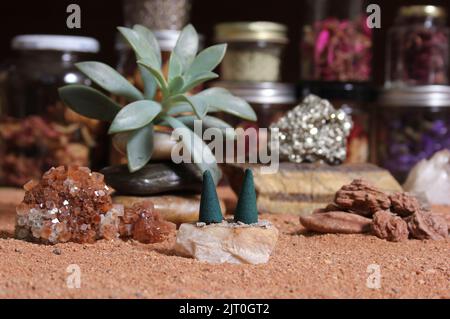 Cristallo di aragonite con coni di incenso sulla sabbia rossa australiana Foto Stock