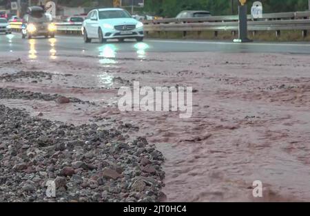 Pforzheim, Germania. 27th ago, 2022. Le automobili guidano lentamente oltre il fango e la ghiaia sull'autostrada. A causa di masse d'acqua e detriti sulla strada, la polizia ha chiuso il raccordo Pforzheim-Ost dell'autostrada 8 in direzione di Stoccarda il venerdì sera. Anche la corsia di destra è stata chiusa per diverse ore perché il fango si stava diffondendo. Credit: Waldemar Gress/Einsatz-Report24/dpa/Alamy Live News Foto Stock