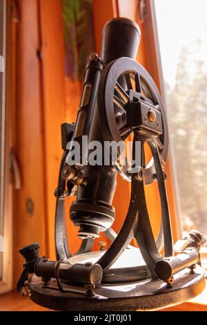 Uno scatto verticale di un vecchio microscopio d'epoca sul tavolo di legno Foto Stock