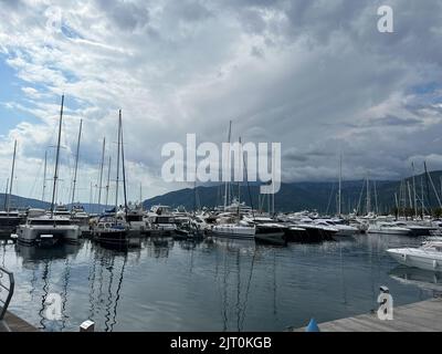 Budva, Montenegro - 27.08.22: Gli yacht a vela si trovano al molo sullo sfondo delle montagne Foto Stock