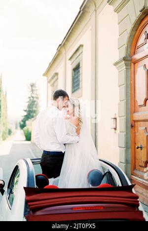 La sposa e lo sposo sono in piedi nel portello dell'automobile Foto Stock